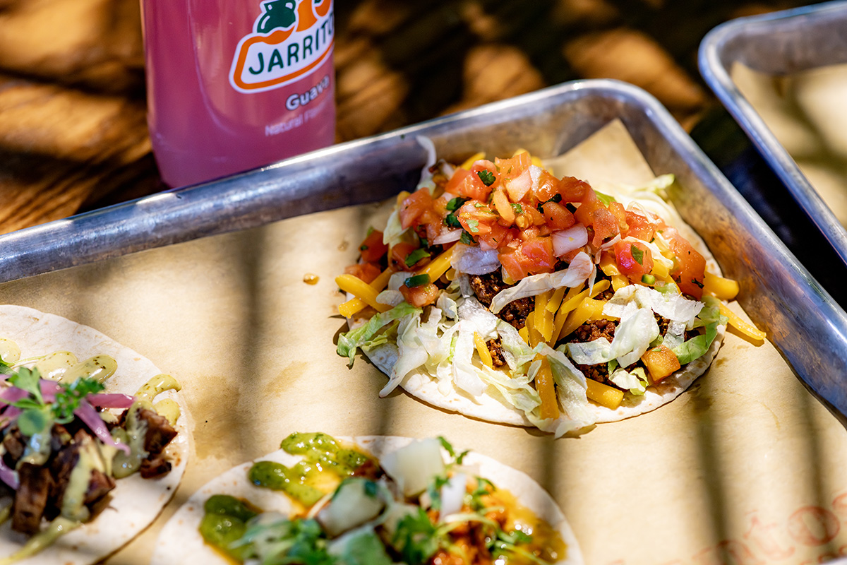 Juntos tacos topped with fresh salsa and herbs